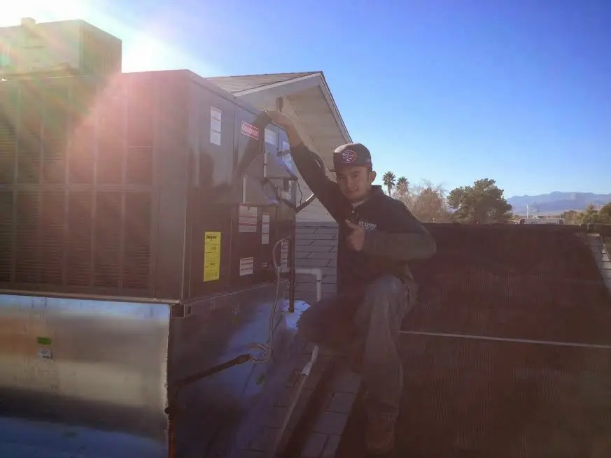 HVAC technician performing Boiler Repair on a rooftop unit in Rochester Hills